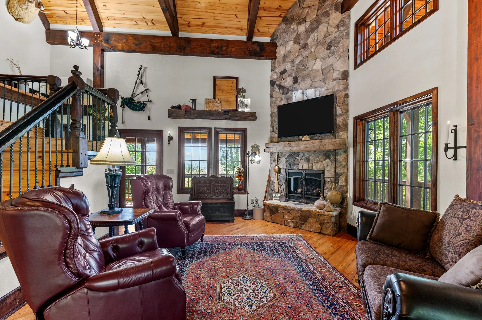 Living Room Detail Living area featuring burgundy leather chairs, ornate fireplace, exposed wood beams and glass doors