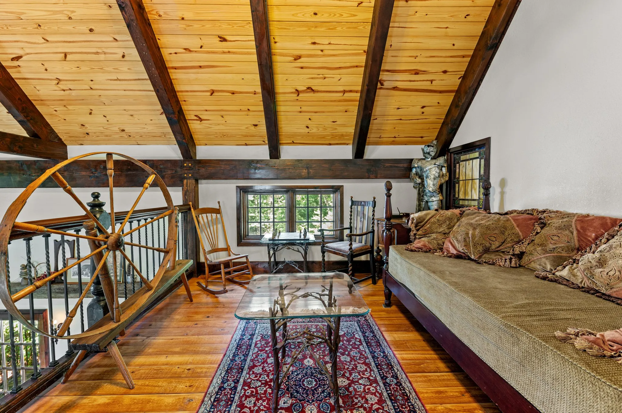 Loft Charming loft sleeping area with decorative wooden wheel, antique furnishings, and rustic decor