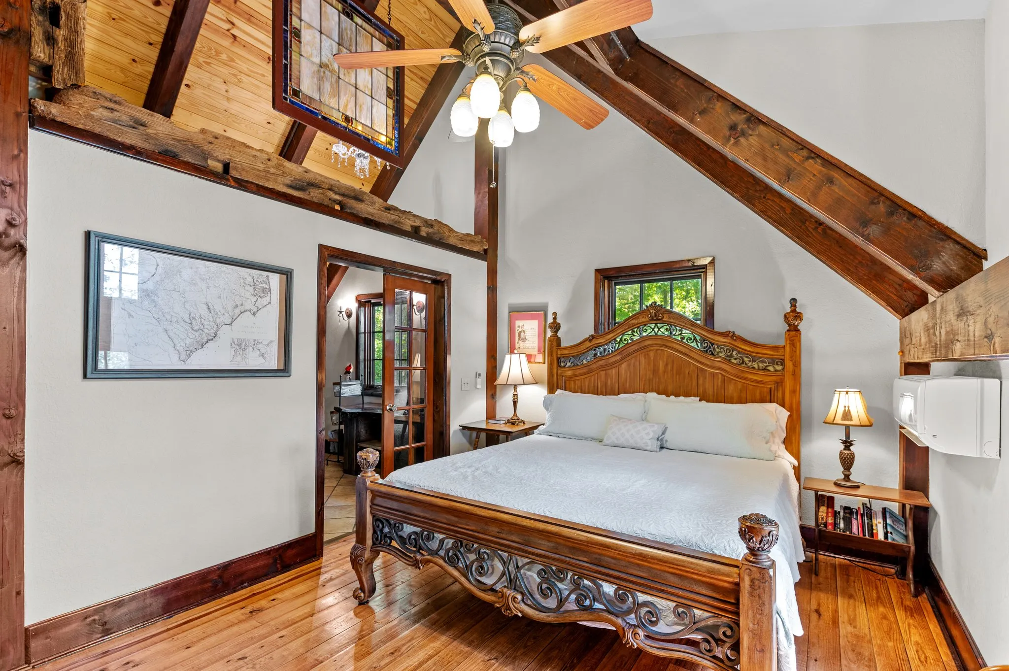 Master Bedroom Elegant master bedroom with ornate wooden bed, high timber ceiling, ceiling fan, and natural light